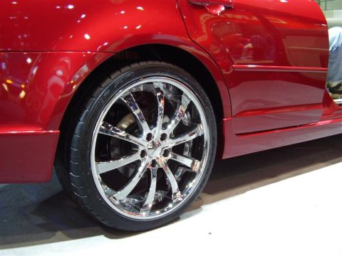 1997 Ford Taurus - A red car with custom chrome wheels and a body kit is shown from the side.