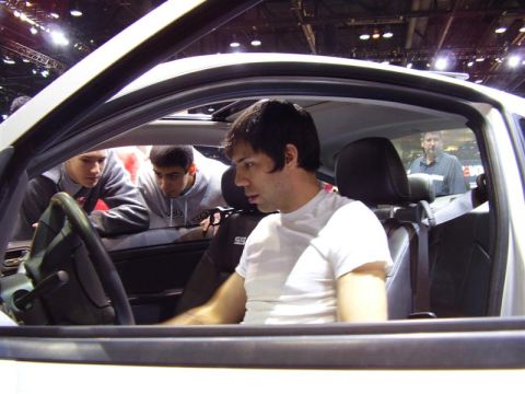 1997 Ford Taurus - People examine the interior of a car at an auto show.
