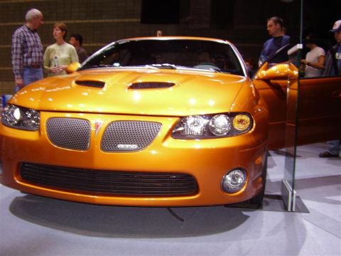 1997 Ford Taurus - Front view of an orange Pontiac GTO at an auto show.