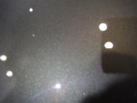1997 Ford Taurus - Close-up of dark metallic car paint with reflections and water spots. Supermotors.net logo visible.