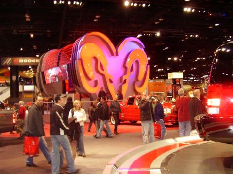 1997 Ford Taurus - A large Dodge Ram logo installation is displayed at an auto show, with several red trucks visible in the background.