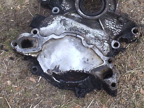 1989 Ford Bronco - This is a worn engine water pump housing lying on the ground.