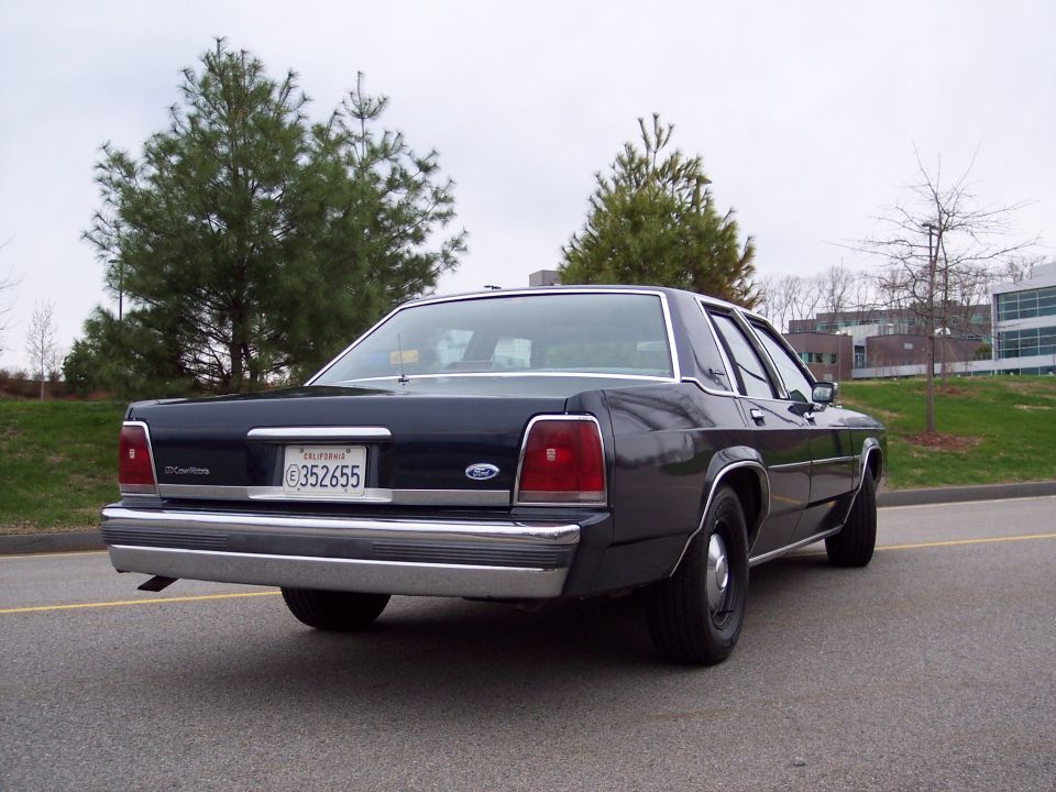 Dark 2001 Ford Crown Victoria sedan, rear view, chrome bumper, California license plate 6352655