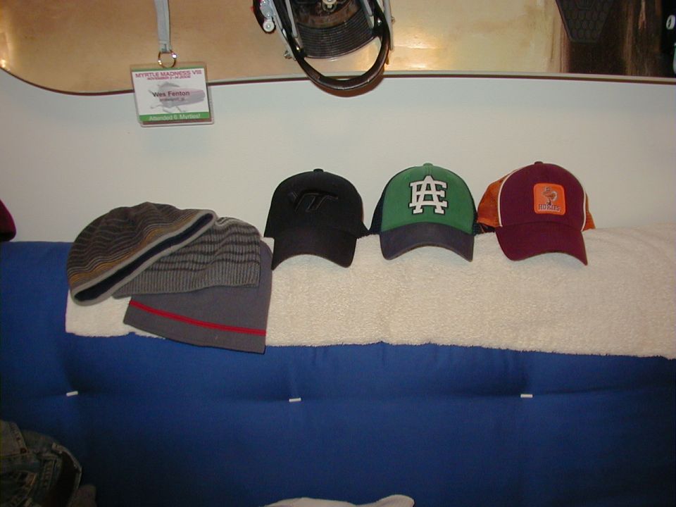 Four hats and a snowboard with a name tag