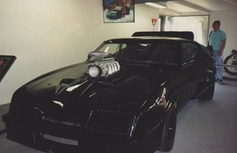 1972 Ford Ranchero - A modified black car with a prominent supercharger is displayed indoors, with a person standing nearby.