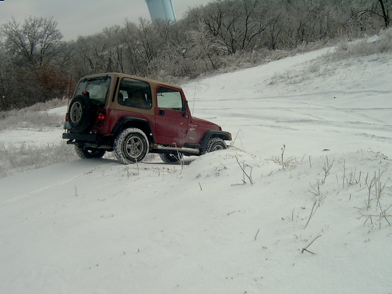Red 1998 Jeep TJ in snow, 3q-front view