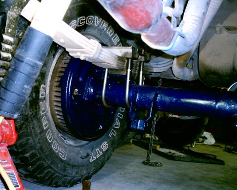 1985 Ford Bronco - Rear axle and suspension components are shown, with a Cooper Discoverer STT tire in view.