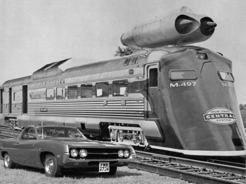 2002 Ford Crown Victoria - A vintage car sits beside the M-497 'Jet Train' of the New York Central System.