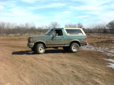 1991 Ford Bronco - This 1991 Ford Bronco is shown in a side profile, parked on a dirt lot.