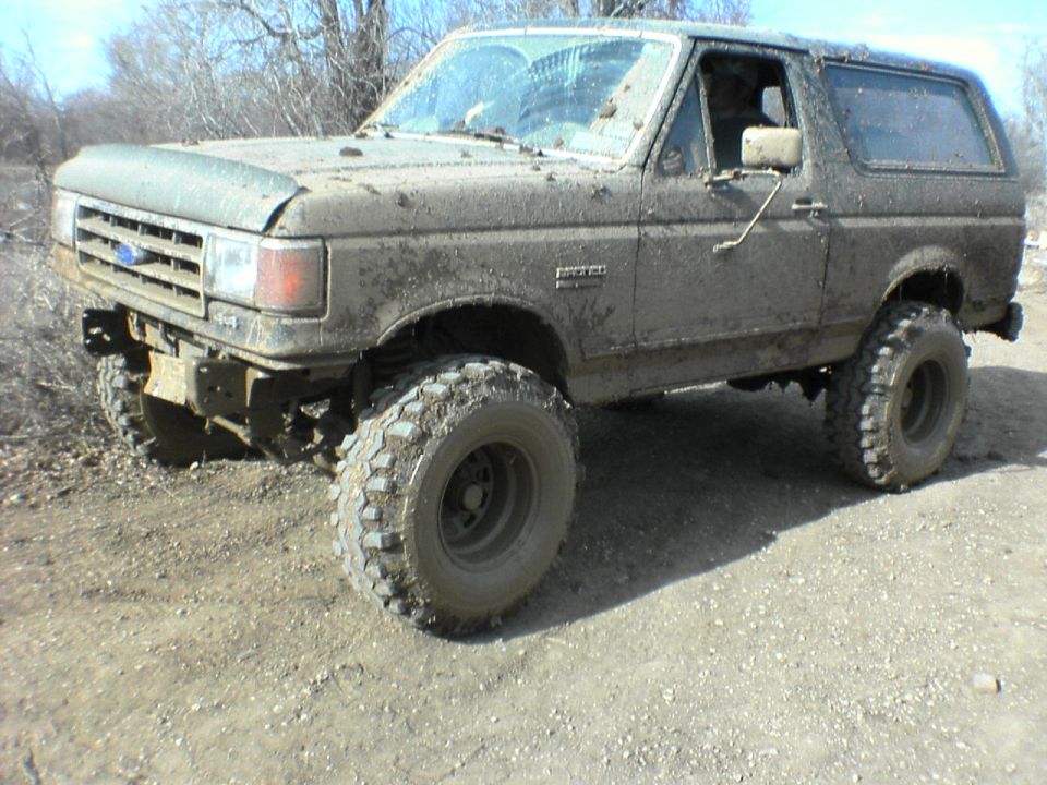 Mud-covered 1991 Ford Bronco, 3q-front view, lifted suspension