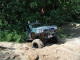 1989 Toyota Tacoma - An off-road vehicle navigates a sandy trail amidst dense foliage.