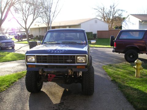 1986 Ford Bronco II - Front view of a lifted 1986 Ford Bronco II, with another Bronco II visible on the right.