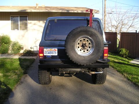 1986 Ford Bronco II - Rear view of a dark blue Ford Bronco II with a spare tire and aftermarket bumper.