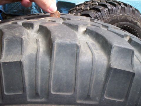 1991 Ford Bronco - A penny is used to measure the tread depth on a large off-road tire.