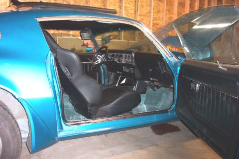 1979 Pontiac Trans Am - Interior view of a 1979 Pontiac Trans Am, showing custom black seats and teal carpeting.