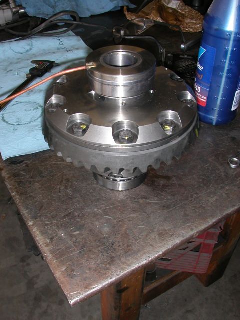 1984 Ford Bronco - A differential locker part sits on a metal workbench next to a bottle of Valvoline fluid.