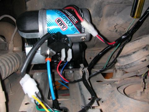 1984 Ford Bronco - Close-up of an ARB Air Compressor installation with visible wiring and tubing.
