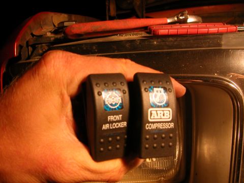 1984 Ford Bronco - Two ARB switches are held up, one for a front air locker and the other for an air compressor.