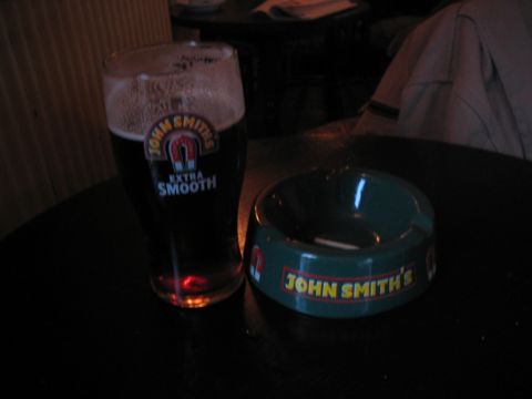 1992 Ford Bronco - A glass of John Smith's Extra Smooth beer sits beside a branded ashtray on a dark table.