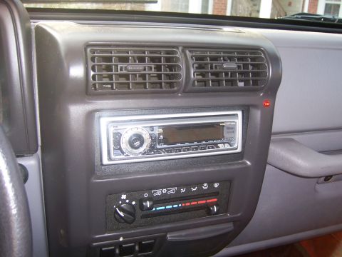 1998 Jeep TJ - Close-up of the center console in a Jeep Wrangler, showing the radio and HVAC controls.