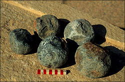 1985 Ford Bronco - Several cannonballs are displayed on a rocky surface, with a ruler indicating their size.