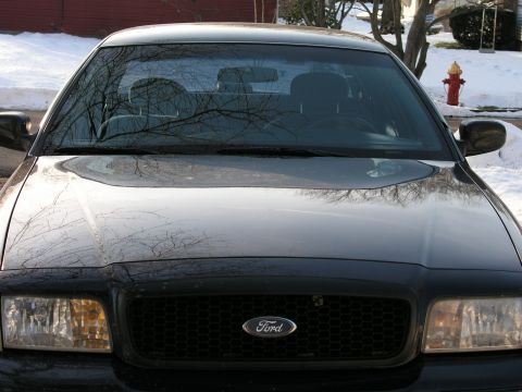 1999 Ford Crown Victoria - A black Ford Crown Victoria is parked outside in the snow, with a fire hydrant nearby.
