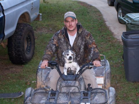 1979 Ford F-150 - A man and his dog enjoy a ride on a camouflage ATV in an outdoor setting.