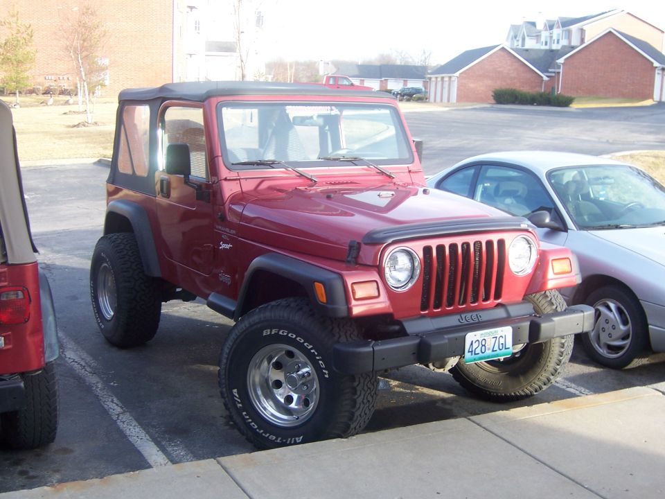 Red 1998 Jeep TJ parked next to a silver sedan