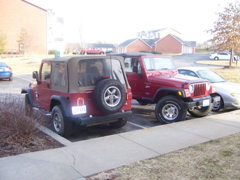 1998 Jeep TJ - Two red Jeep Wranglers are parked next to each other in a parking lot.