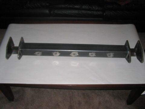 1991 Ford Bronco - A custom-fabricated metal axle component, likely for off-road or heavy-duty use, is displayed on a table.