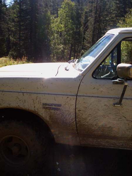 1991 Ford Bronco - This 1991 Ford Bronco is seen from the side, heavily coated in mud from off-road use.