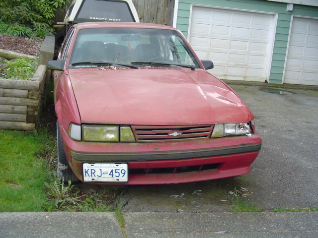 Red sedan with damaged headlight and grille