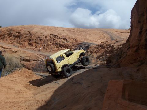 1991 Ford Bronco - An off-road vehicle navigates a challenging rocky terrain under a cloudy sky.