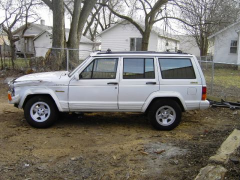 1992 Jeep Cherokee - Side profile of a white 1992 Jeep Cherokee, identified by its 'Limited' badge and overall body style.