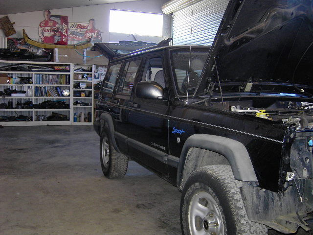 Black 1998 Jeep Cherokee with hood open in a garage