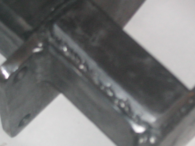 Close-up of a welded metal bracket with visible weld beads