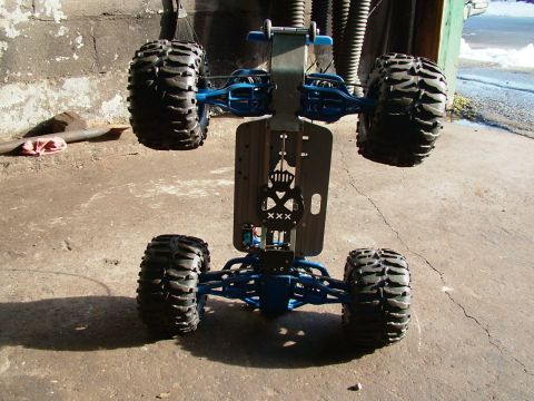 1994 Ford Bronco - The underside of a remote control monster truck chassis is shown, large tires and blue suspension parts.