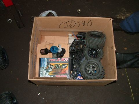 1994 Ford Bronco - A box contains RC car parts, including a TRX 25R racing engine and several tires, along with other components.
