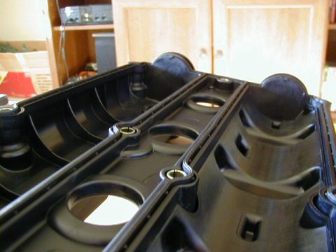 1994 Ford Probe - Close-up of a black plastic engine valve cover, showing internal structure and mounting points.