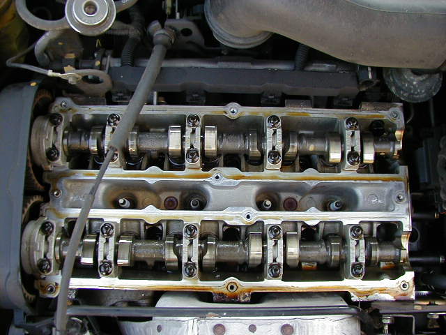 Engine with exposed camshafts and valves, showing oil residue