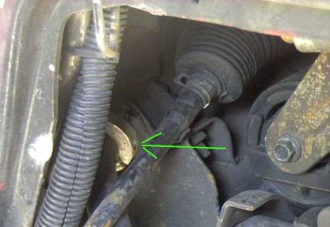 1997 Ford Taurus - Tight under-hood shot of a suspension and steering area with a green arrow drawn on the image pointing to a specific bushing or collar on a…