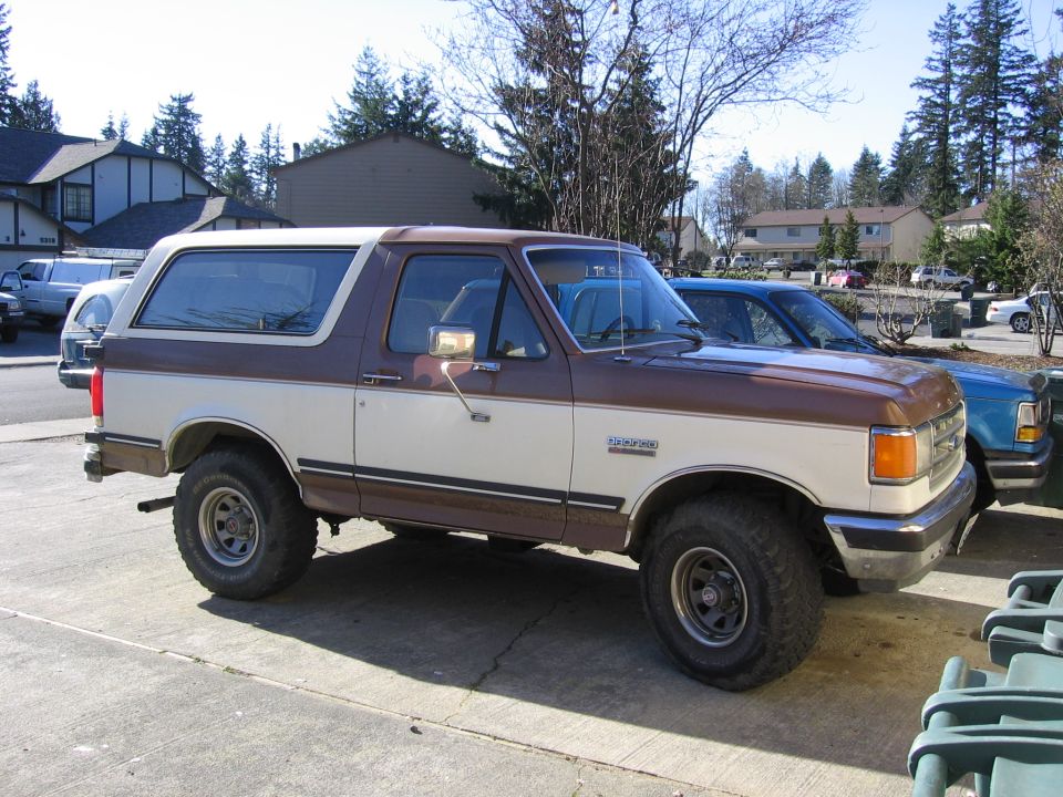 1987 Ford Bronco XLT parked on concrete, brown and white two-tone paint