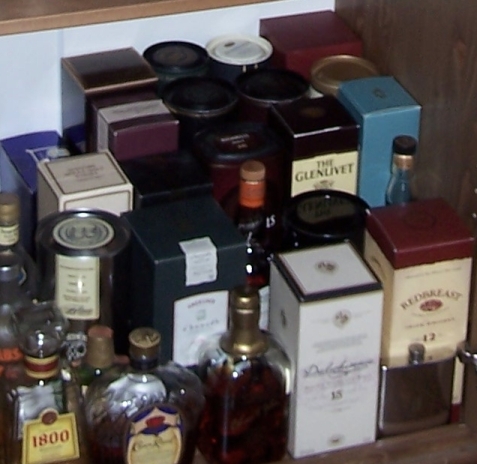 1990 Ford Bronco - Various bottles and boxes of alcoholic beverages are arranged on a shelf.