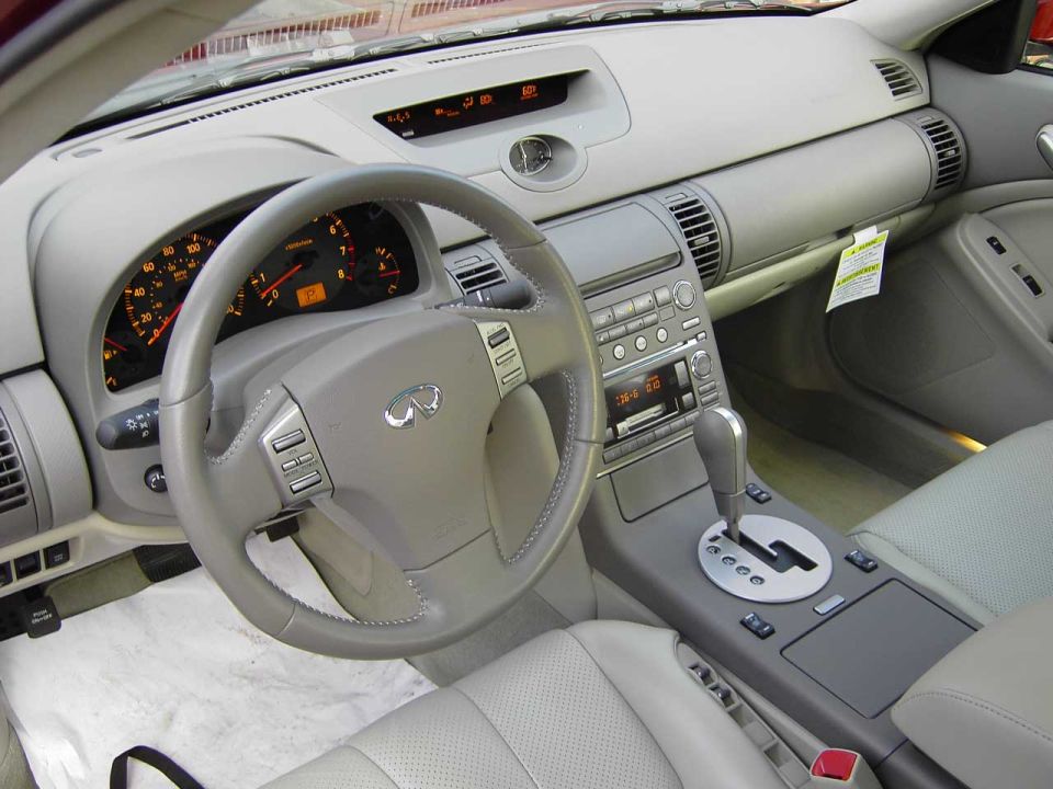 Light gray leather interior and dash of an Infiniti G35 with automatic shifter
