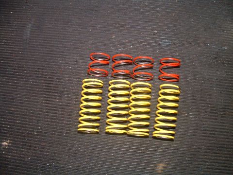 1994 Ford Bronco - Several red and yellow coil springs are arranged on a dark, ribbed surface.