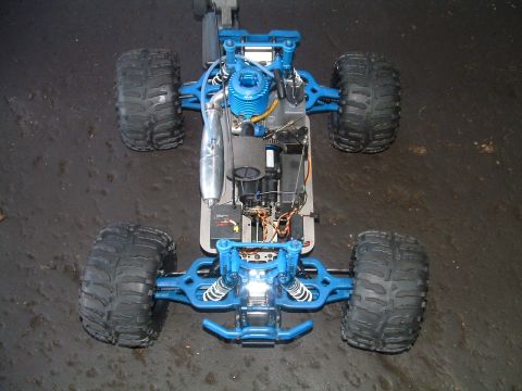 1994 Ford Bronco - A blue remote control monster truck is viewed from above, showing its internal components and large off-road tires.