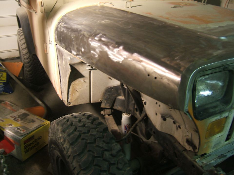 1989 Jeep YJ front fender being repaired, showing bare metal and bodywork