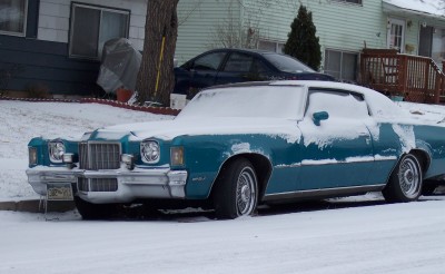1972 Ford Ranchero - A teal coupe sits partially covered in snow on a street, with another car parked behind it.