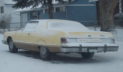 1972 Ford Ranchero - Rear view of a 1974 Mercury Cougar sedan parked outside in the snow.