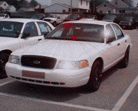 2000 Ford Crown Victoria - White 2000 Ford Crown Victoria police car parked in a lot, showing its front and side profile.